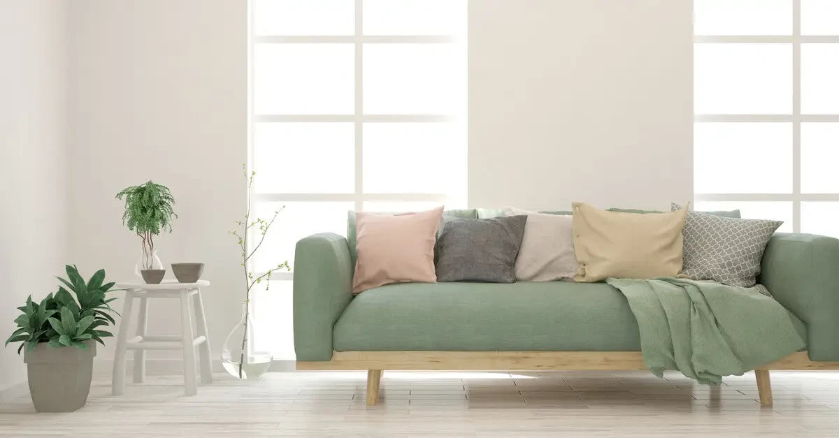 Mint green sofa with colorful pillows and blanket, ideal for custom-made furniture covers.