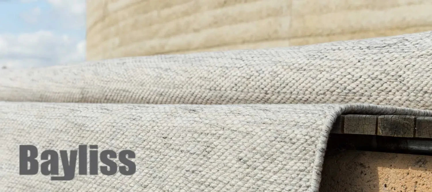 Beige upholstered furniture with Bayliss text showcasing quality rugs in DYS article.