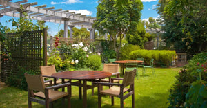a wooden dining table set in lush garden setting
