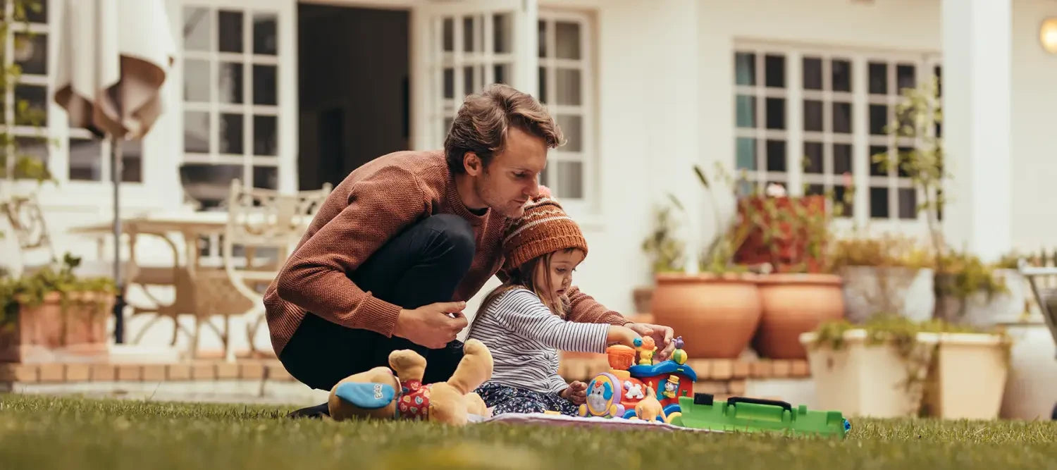 Adult and child playing with toys on a lawn to stay healthy during unprecedented times.