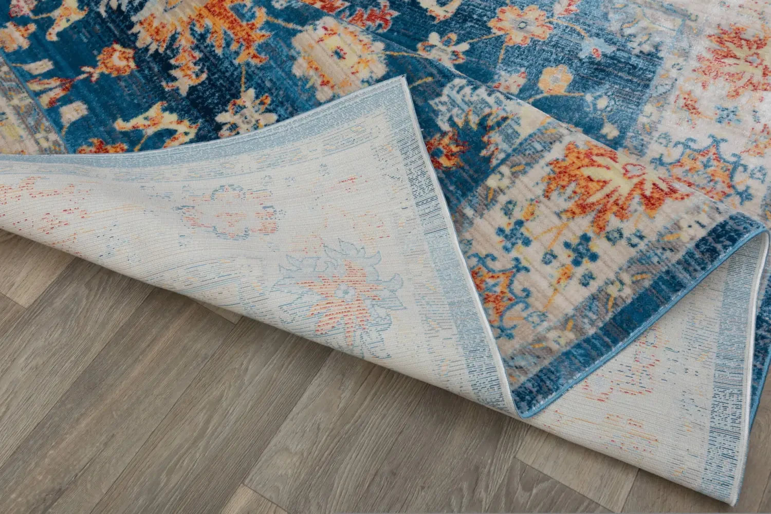 Colorful patterned Bayliss rug with corner folded, showcasing its quality underside.