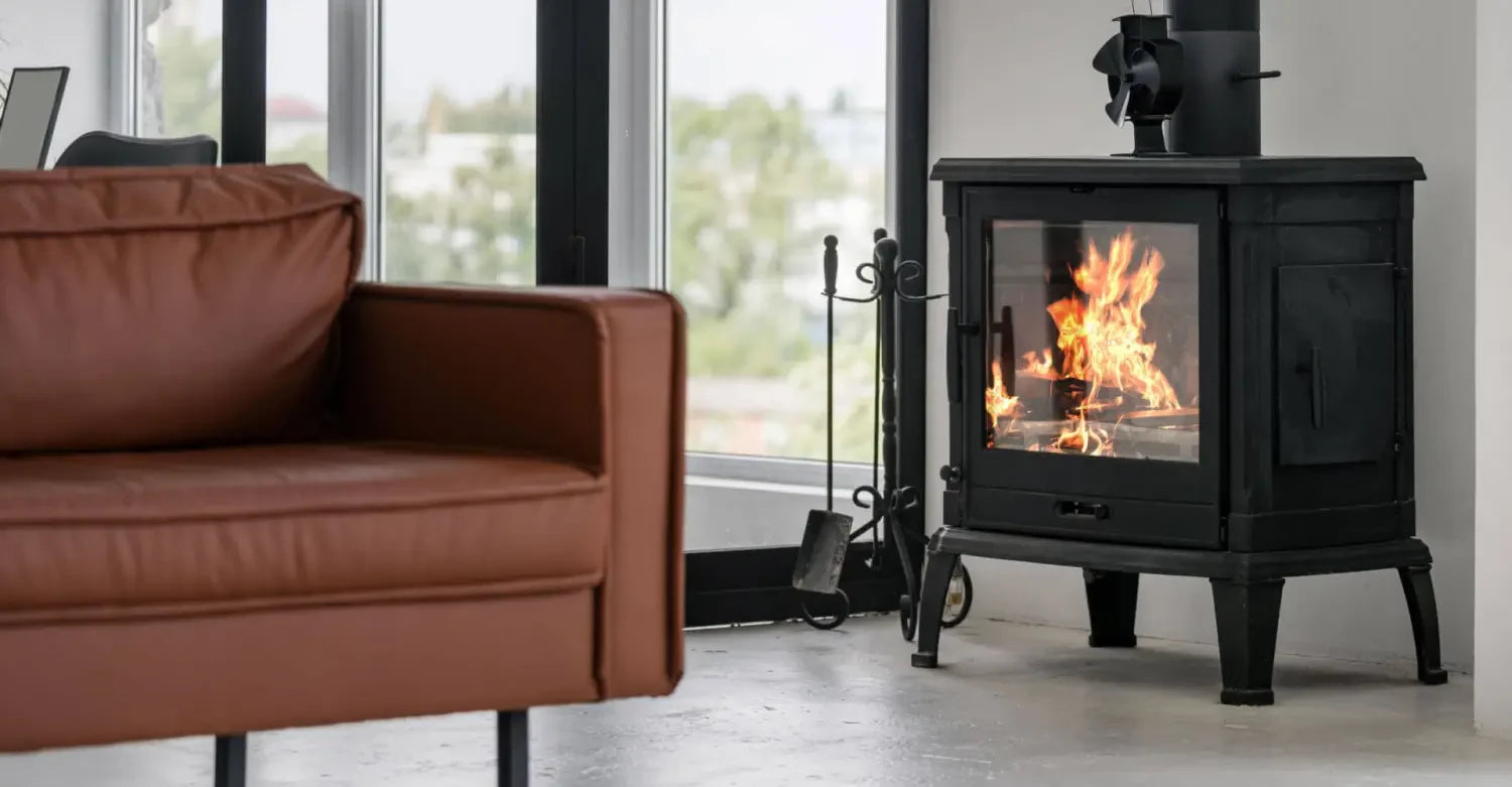 Wood-burning stove with fire seen through glass door enhancing indoor space and furniture styles