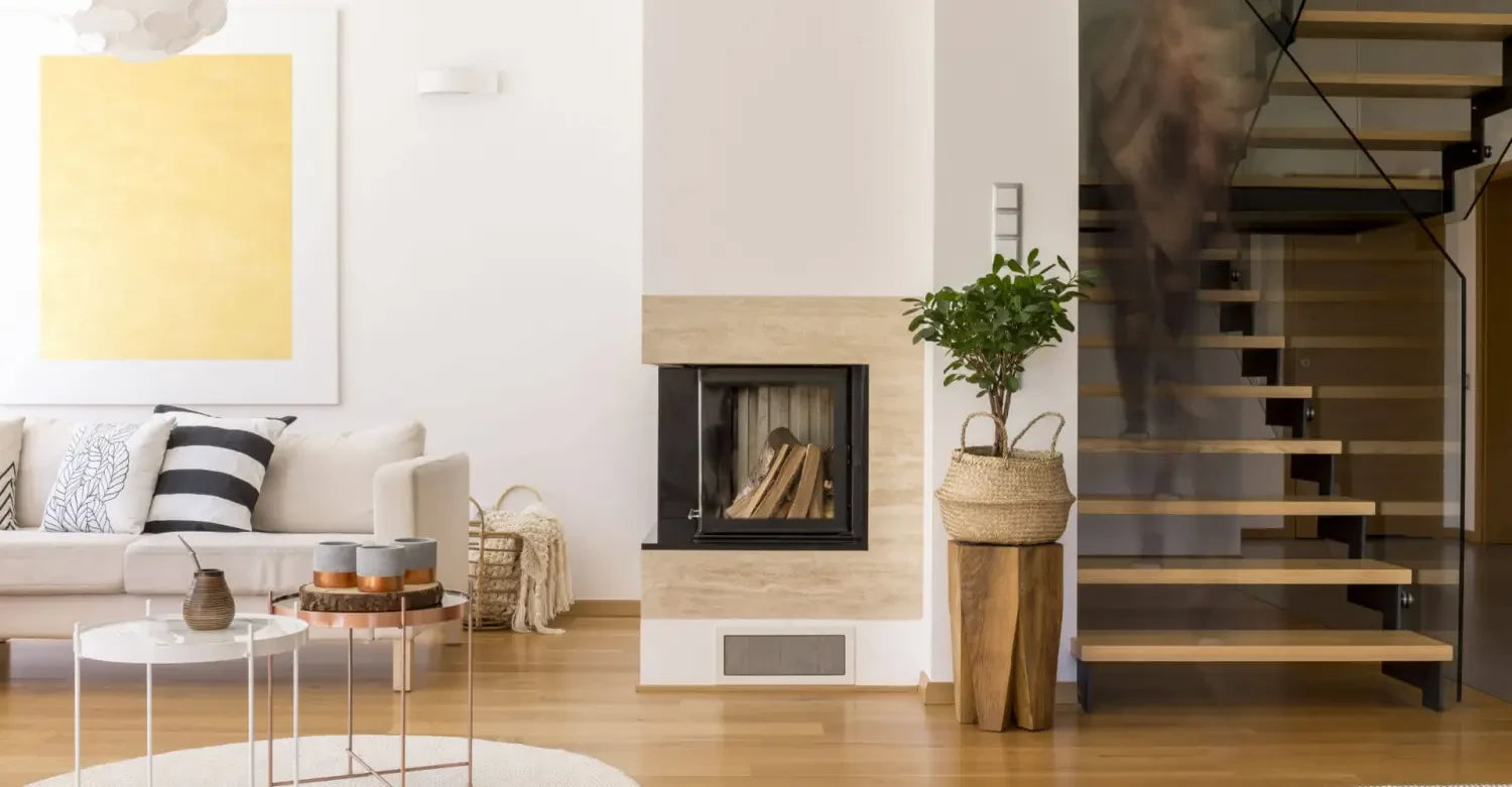 Modern living room featuring a minimalist fireplace and floating staircase with Bayliss rugs.