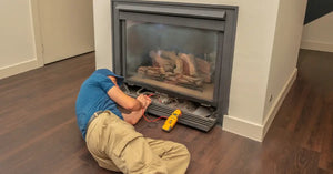Service technician working on a gas fireplace inside of a residential home