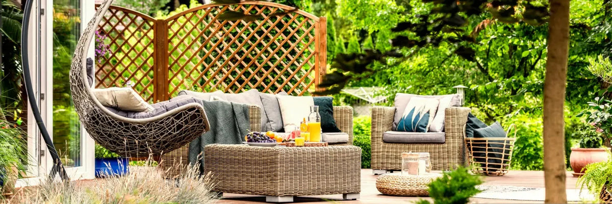 Outdoor patio furniture set featuring wicker chairs and a hanging egg chair.