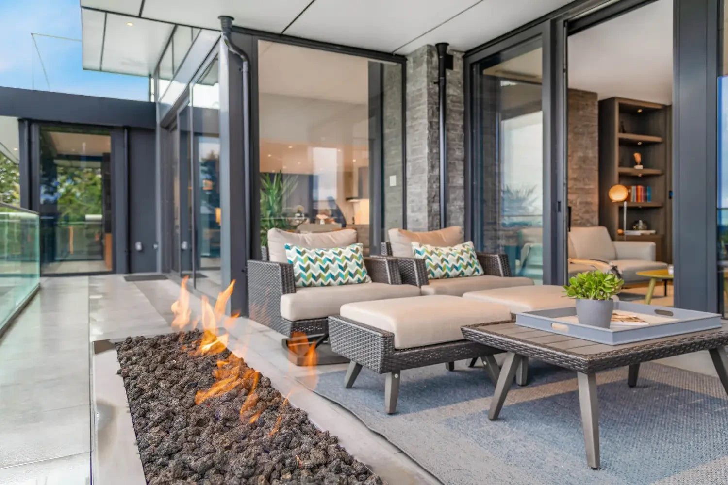 Outdoor patio seating area with a linear fire feature and Nardi dining sets for entertaining.