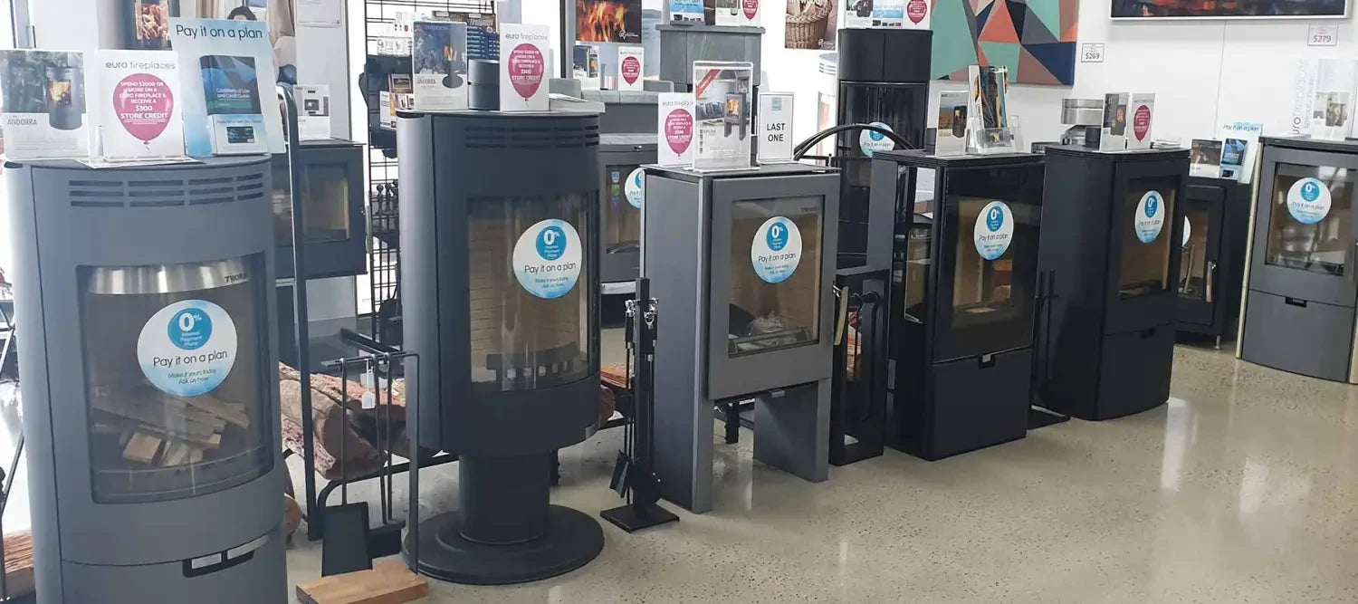Row of efficient wood heaters displayed in a retail setting for safe home heating.