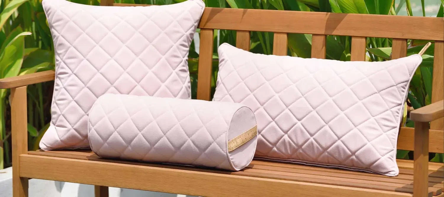 Wooden bench with quilted white outdoor cushions for a great outdoor space.
