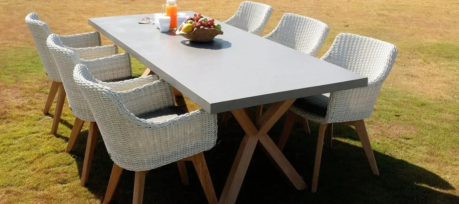 Outdoor dining set featuring a rectangular table and six woven wicker chairs for unique character