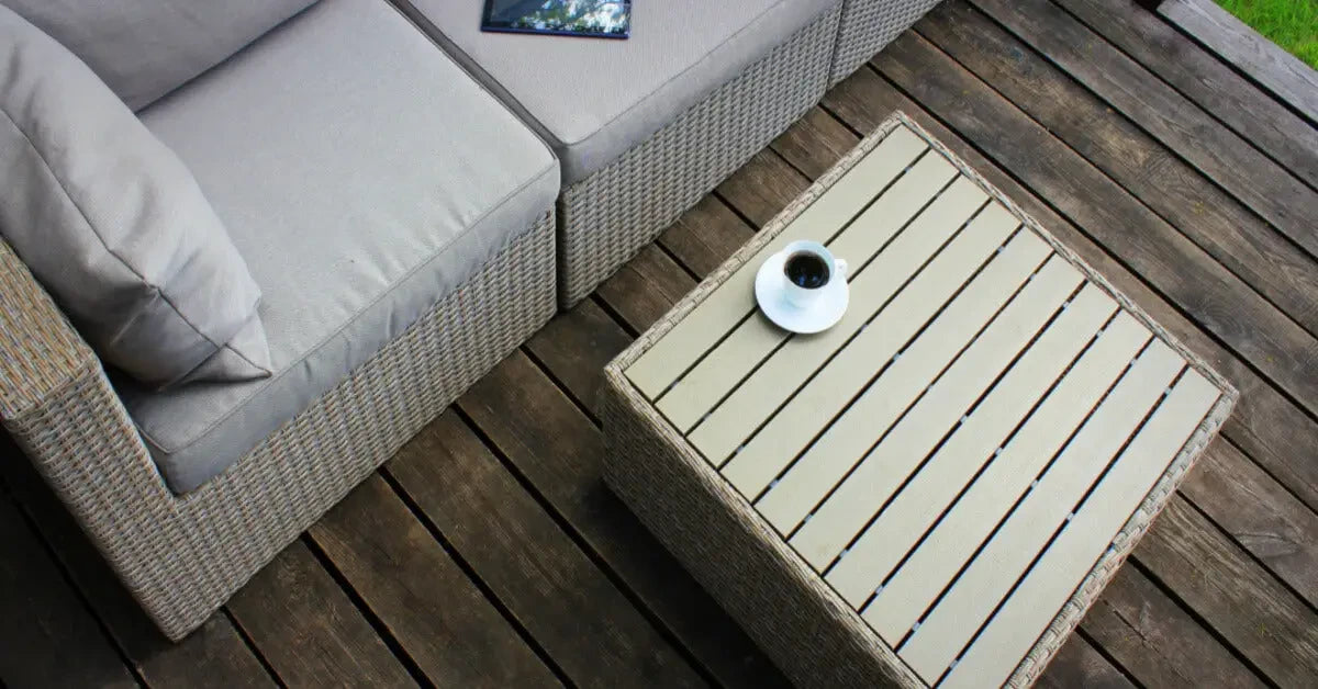 Stylish outdoor sofa with light cushions and matching coffee table for summer lounging.