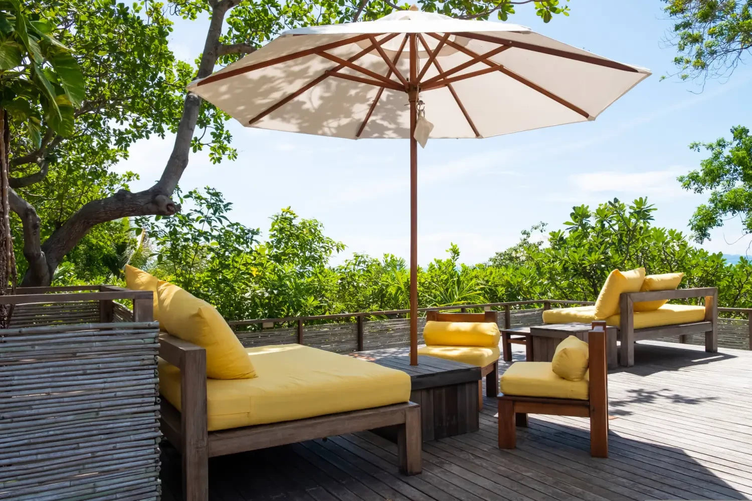 Outdoor patio furniture set with yellow cushions under a shade umbrella for instant shade