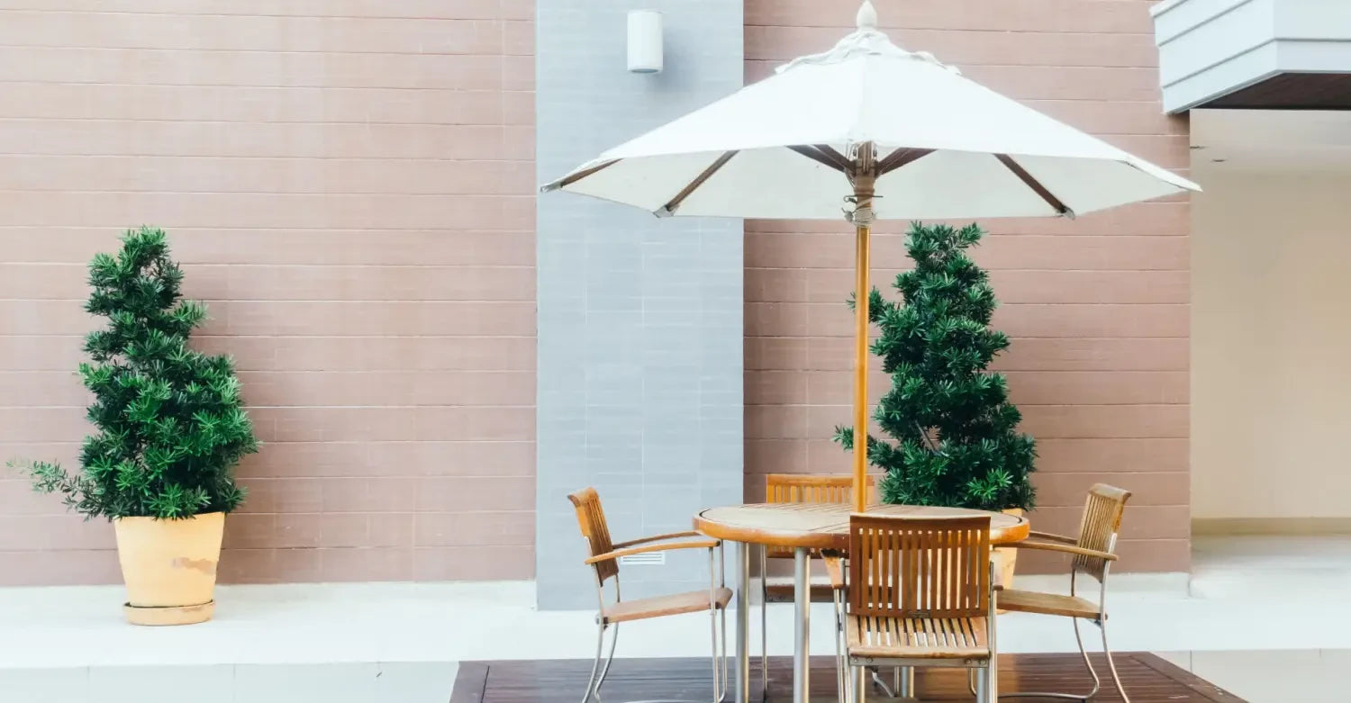 Patio umbrella providing instant shade over a wooden outdoor dining set for any weather.