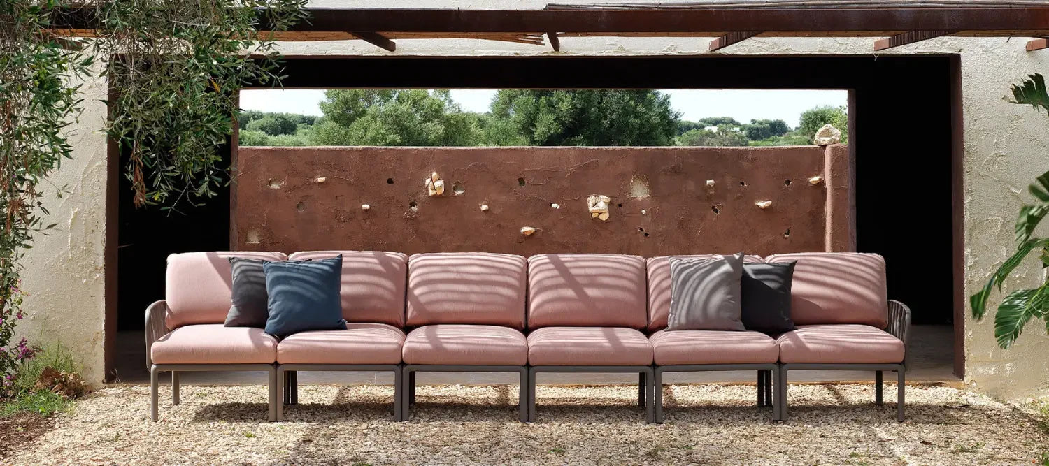 Pink sectional sofa with dark accent pillows from Nardi outdoor furniture collection.