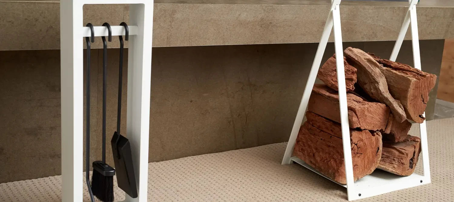 Fireplace accessories including a tool set and firewood holder with stacked logs.